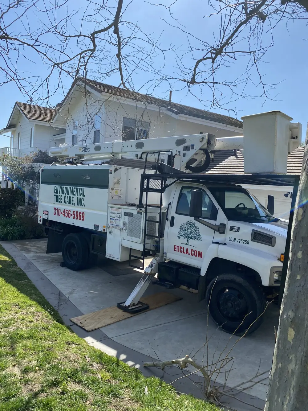 Environmental Tree Care branded bucket truck at a residential property